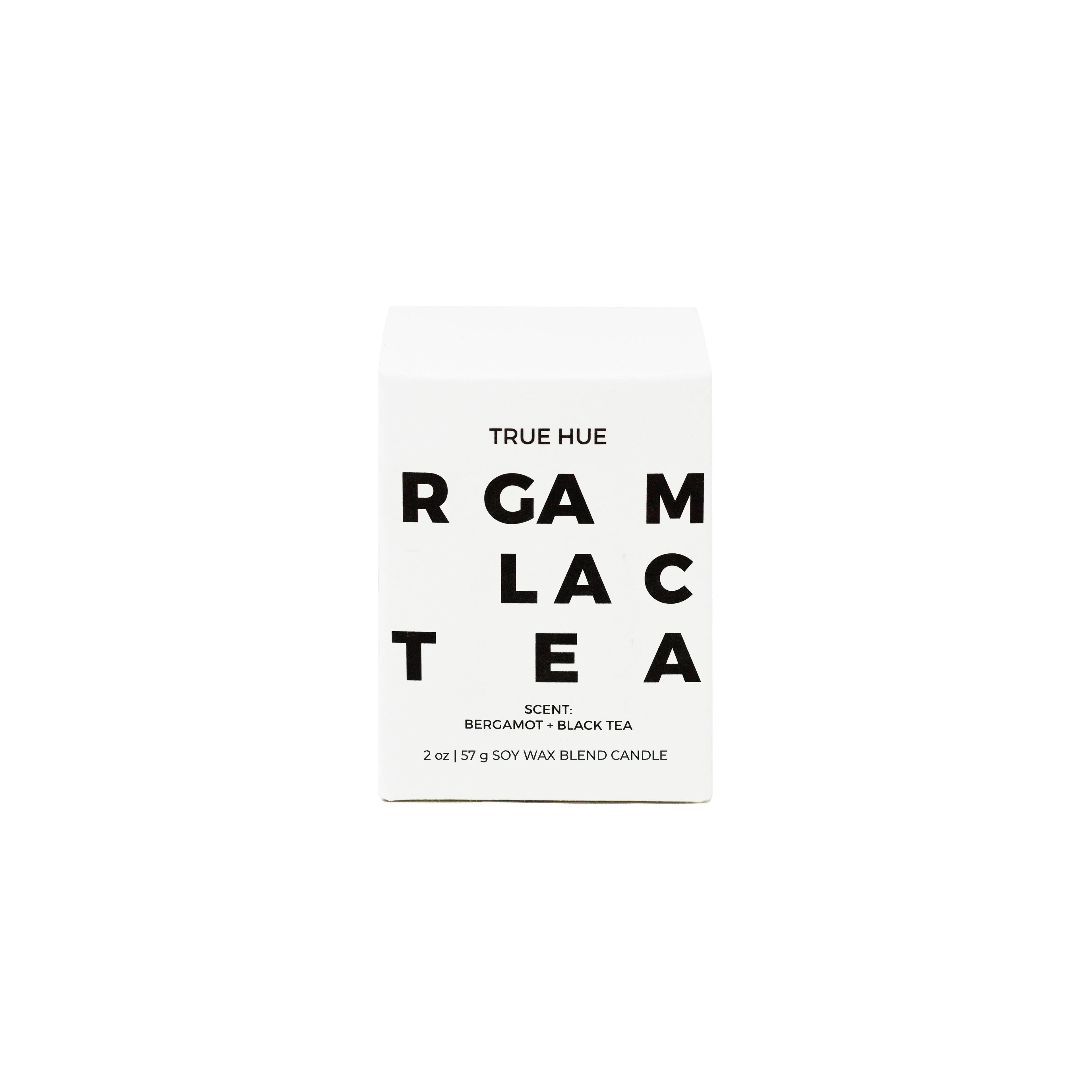 True Hue Bergamot and Black Tea mini candle with a white ceramic holder and a soft flickering flame.