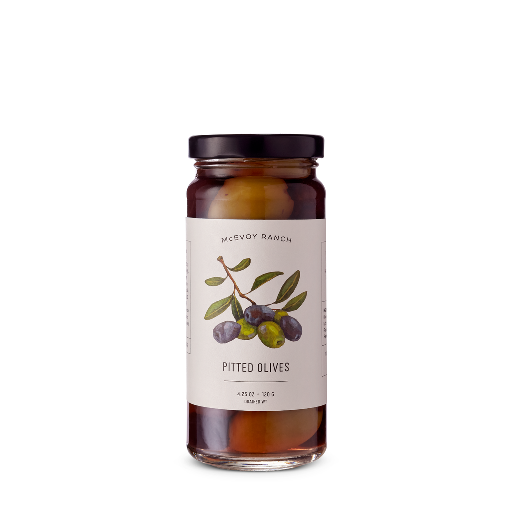 McEvoy Ranch pitted table olives in a 4.25 oz jar, showcasing shiny, green olives ready for snacking or cooking.