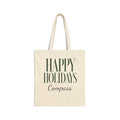 An off-white canvas tote bag with dark green text reading 'HAPPY HOLIDAYS Compass' on the front, shown against a plain white background.
