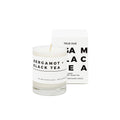True Hue Bergamot and Black Tea mini candle in a glass jar with a lit wick, showcasing a cozy, aromatic candle for relaxation.