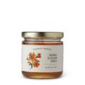 Jar of McEvoy Ranch Orange Blossom Honey, a condiment with golden honey and orange blossom aroma in a glass jar.
