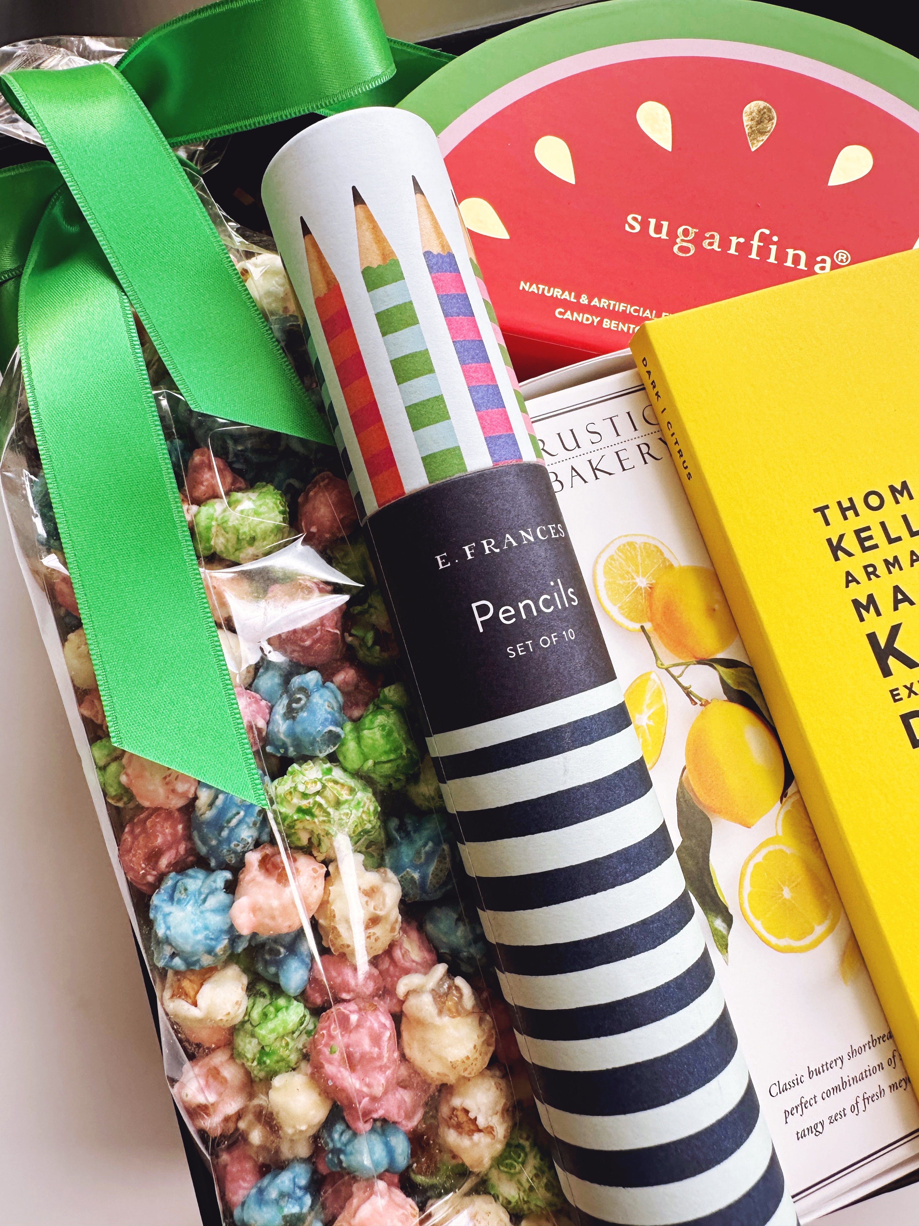 Gift set with popcorn, candy, and stationery items including a striped pencil and colorful candy.