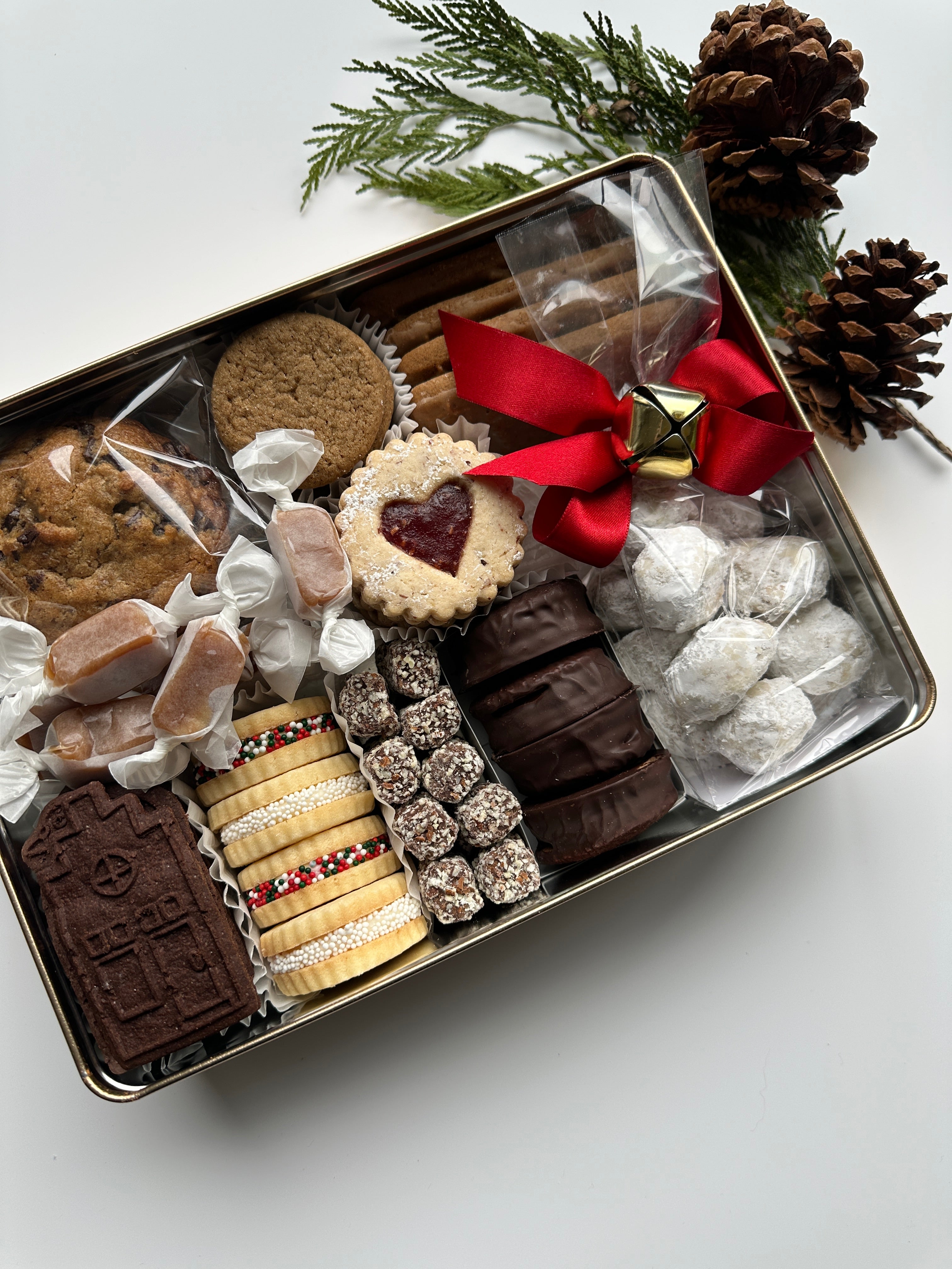 Large rectangle tin filled with assorted cookies for holiday gifting.
