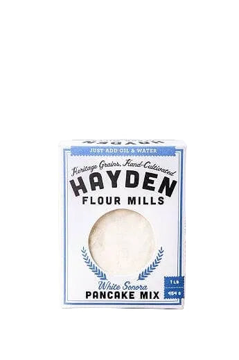 White Sonora pancake mix from Hayden Flour Mills, shown in a bag with fresh ingredients and a prepared pancake on a plate.