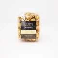 Mini vanilla bean cocoa nib caramel popcorn snack by The Art of Caramel, showing golden popcorn coated with vanilla and cocoa nibs.